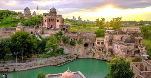 Stone temples at Katas Raj with a reflective pond in the center.