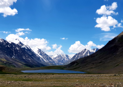 Shandur Pass: A high-altitude plateau with lush green meadows and snow-capped mountains in Pakistan.